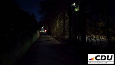 Ein Stück vor der Einmündung des Kirschgartens ist es besonders dunkel. Die Laterne beleuchtet praktisch ausschließlich die Straße.